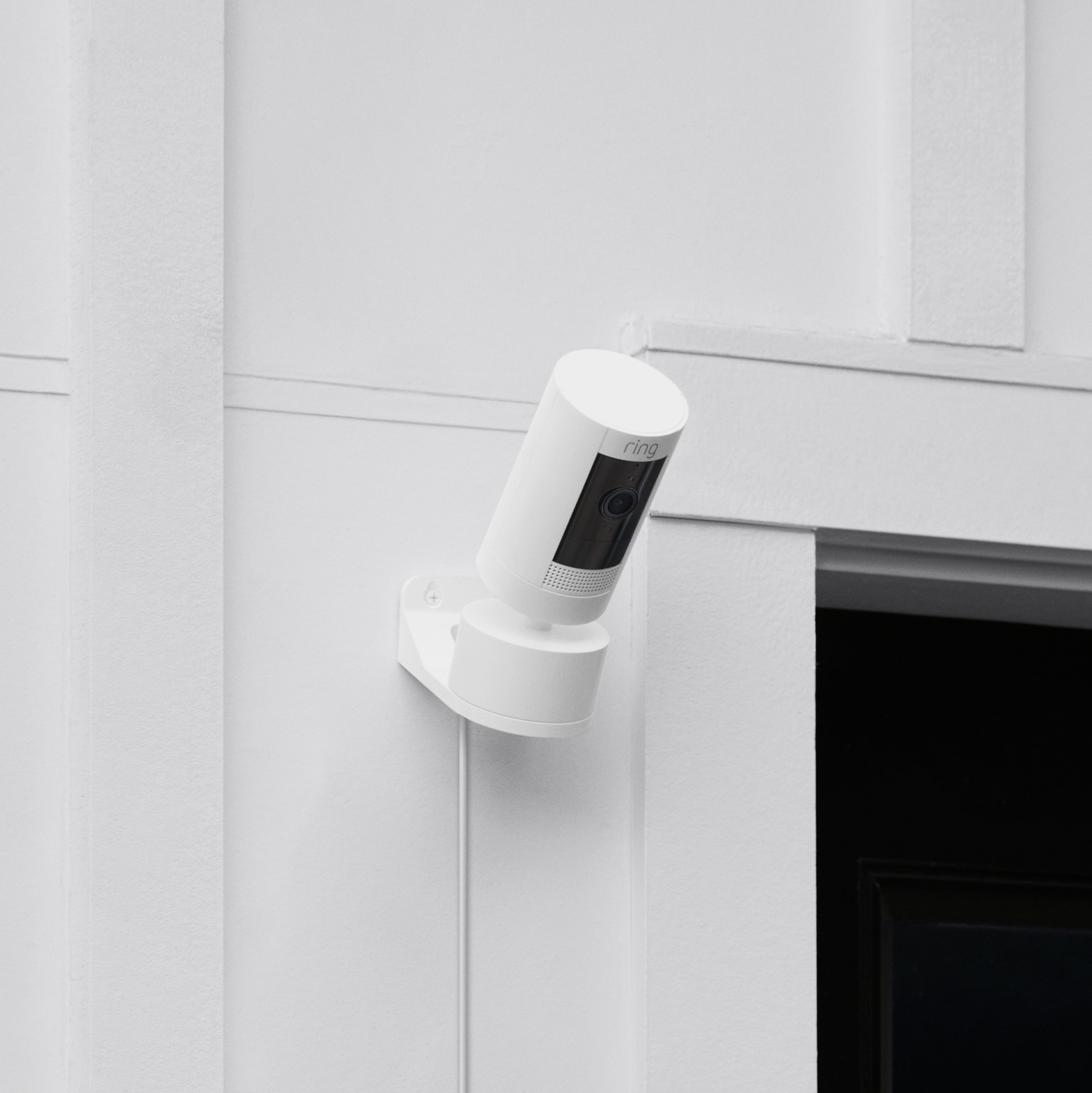 Pan-Tilt Mount with Indoor/Outdoor Power Adapter (for Stick Up Cam Plug-In, 3rd Gen) - White Ring Stick Up Cam attached to a Pan-Tilt Mount with Indoor/Outdoor Power Adapter on wall next to garage door.
