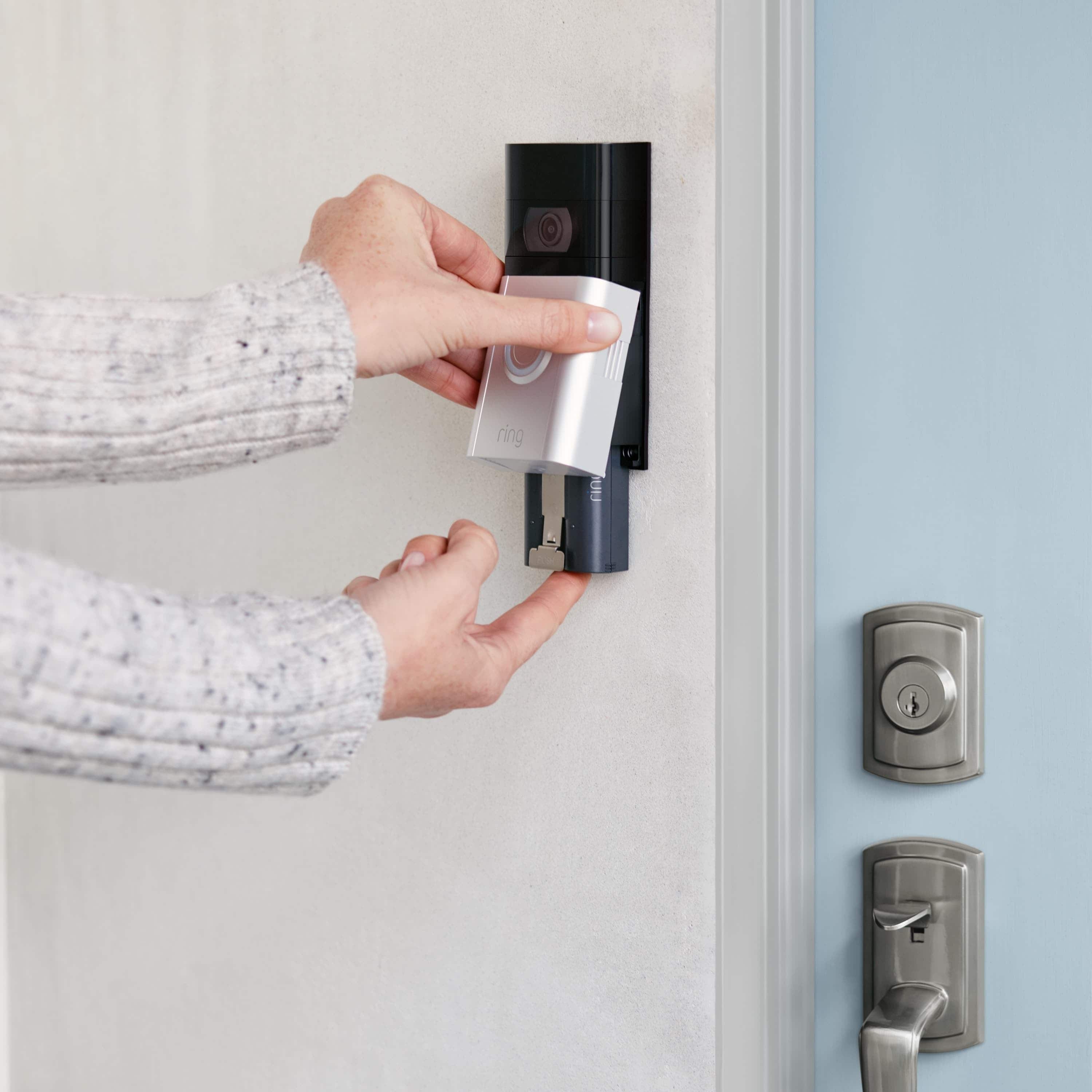 Quick Release Battery Pack - Person removing Quick Release battery Pack from a mounted Ring video doorbell by a front door.