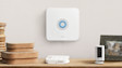 Ring Alarm Base Station, a white Ring security camera, and a Ring Alarm Keypad on a wooden surface
