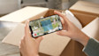 Hands holding a smartphone displaying a back garden scene
